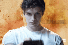 a man in a white t-shirt is holding a camera in front of a mtv logo