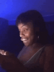 a woman is looking at a cell phone in the dark .