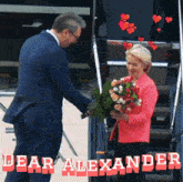 a man in a suit is giving flowers to a woman in a pink jacket with the words dear alexander behind them