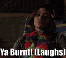 a woman wearing a flower lei is laughing with the words ya burnt laughs below her