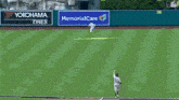 a baseball player is catching a ball in front of a memorial care sign