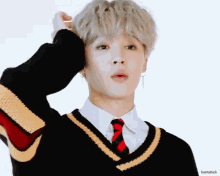 a close up of a person wearing a sweater and tie with heartattack written on the bottom right