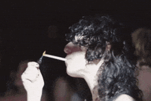 a woman with curly hair is lighting a cigarette