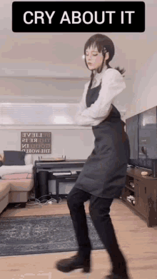 a woman in an apron is dancing in a living room with the caption cry about it