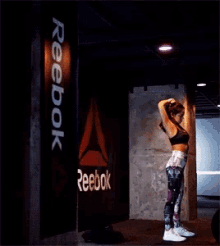 a woman with a tattoo on her back is bending over in a dark room