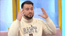 a man with a beard wearing a sweater with the word gant on it .