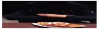 a person is taking a slice of pizza from a plate of waffles .