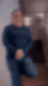 a blurry picture of a man in a blue shirt kneeling down