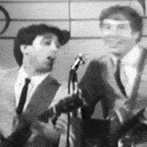 a man in a suit and tie is singing into a microphone