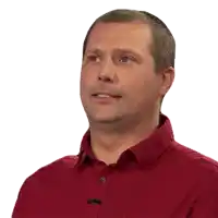 a man wearing a red shirt has a microphone on his shirt