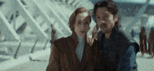 a man and a woman are standing next to each other on a bridge