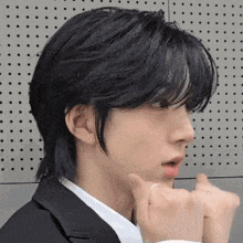 a close up of a person 's face with black hair and a white shirt