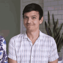a man wearing a white striped shirt is smiling