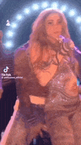a woman is standing in front of a microphone on a stage .