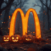 a mcdonald 's logo is lit up with pumpkins in front of it