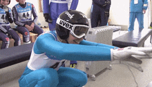 a person wearing a helmet that says uvex is squatting down