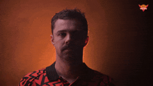 a man wearing a red and black shirt has a crown on his shirt