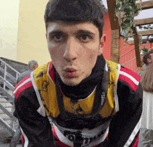 a man wearing a shirt that says ' nikon ' on it looks at the camera