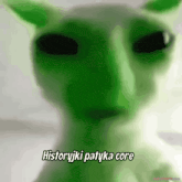 a blurry picture of a green alien with the words historyjki patyka core written below it