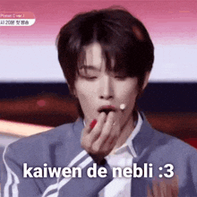 a young man is eating a strawberry with the words kaiwen de nebli : 3 written on it .