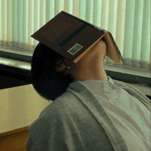 a woman laying down with a book on her head that has a barcode on it