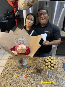 a man in a white cap shirt stands next to a woman with a bouquet of flowers and a sign that says happy anniversary
