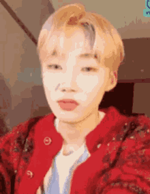a close up of a person wearing a red jacket and taking a selfie .