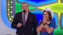 a man in a suit and tie stands next to a woman in a blue shirt that says ' superhero '