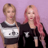 two girls with pink hair are standing next to each other on a purple background .