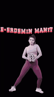 a woman in a pink top and purple pants is holding a pair of shoes and the words e-erdemin manii are visible