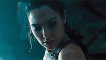 a close up of a woman 's face with a ponytail in a dark room .