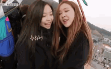 two girls are standing next to each other on a ferris wheel and smiling