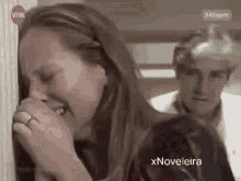 a woman is crying in front of a tv screen that says viva