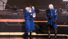 a group of people in blue uniforms are dancing on a stage with the name hoshimiruji on the bottom right corner