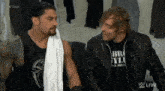 two wrestlers are standing next to each other and one is wearing a black shirt that says brooklyn