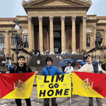three young men holding flags in front of a building with a sign that says lim go home