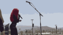 a woman with red hair singing into a microphone with stagecoach written on the bottom left