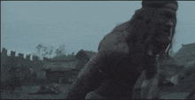 a man is holding a large axe in a dark field