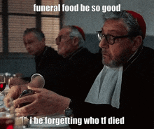 a man is sitting at a table with a glass of wine and a caption that says funeral food
