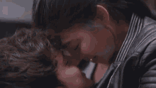 a man and a woman are kissing in front of a mirror .