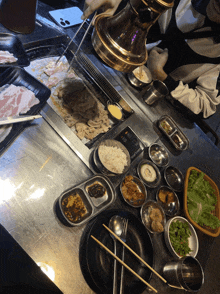 a table with plates of food and chopsticks and a stove that says ' rice ' on it