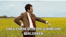 a man in a suit and tie is dancing in a field with the words enes fivem blueve girmesini beklerken below him