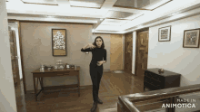 a woman stands in a room with the words made in animotica on the bottom right
