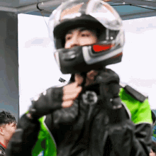 a man wearing a helmet and a green jacket