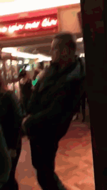 a man is dancing in front of a sign that says ' oyster club ' on it