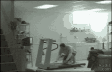a man is kneeling on a treadmill in a basement in a room .