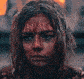 a woman with blood on her face looking at the camera