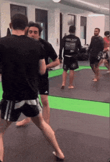 a man in a black chicago shirt is standing in a gym