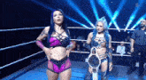two women are standing in a wrestling ring with a championship belt .