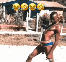 a man in a bathing suit is standing in front of a blue house